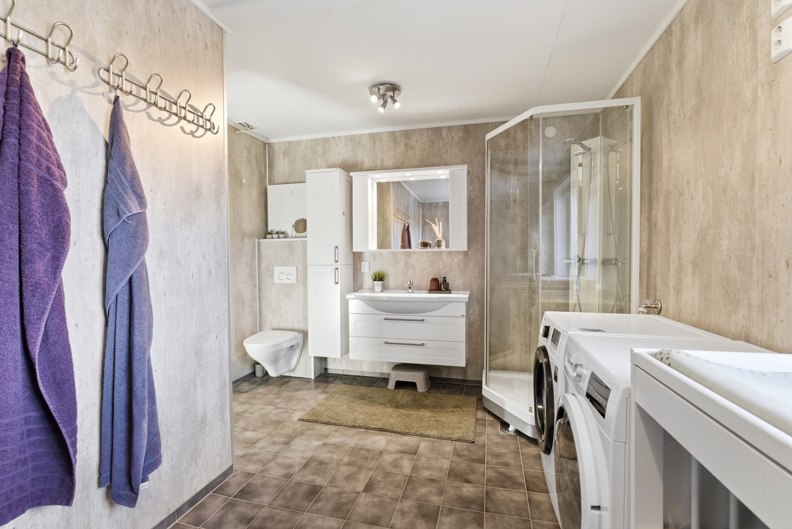 Rommet er utstyrt med dusjkabinett og en moderne baderomsinnredning med god oppbevaringsplass. Galleribilde