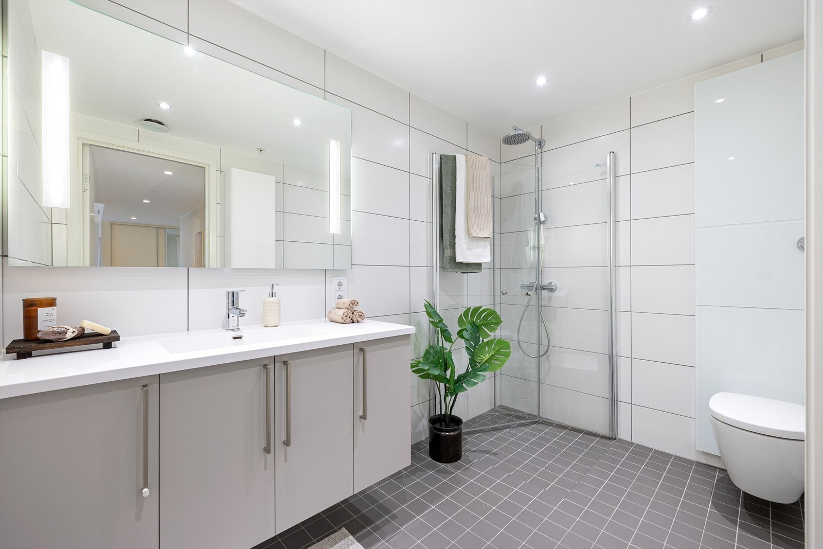 Flislagt baderom på ca. 5.3 m² med dusjhjørne, servant og toalett. Badet fremstår funksjonelt og praktisk innredet. Galleribilde