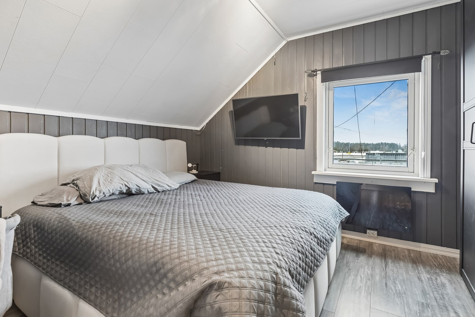 Et av de fire soverommene i andre etasje, med panel på veggene og plass til dobbeltseng. Galleribilde