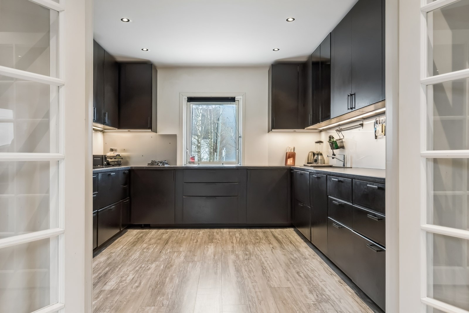 Innredningen har glatte, mørke fronter og laminert benkeplate som gir et stilrent uttrykk. Galleribilde