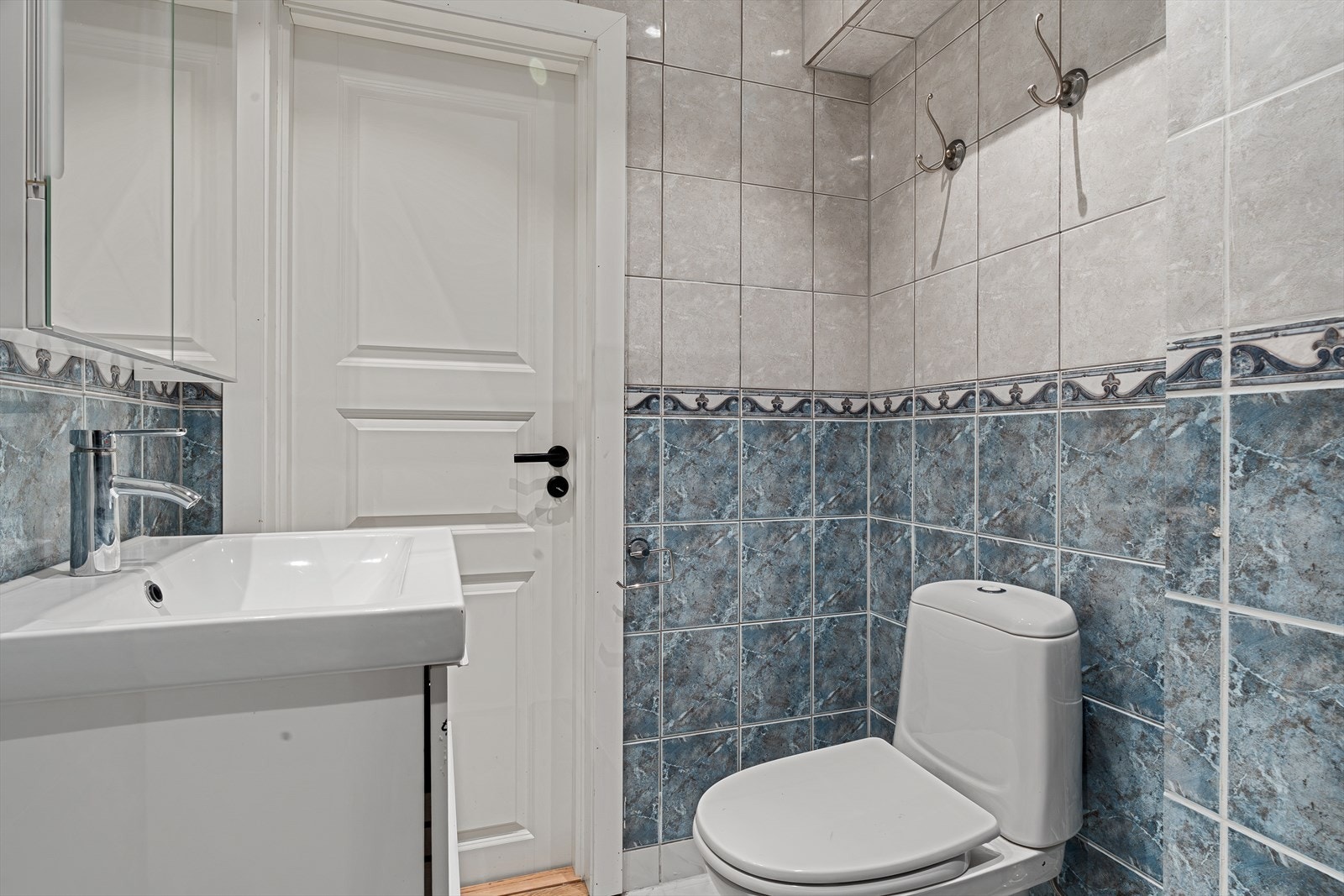 Helfliset bad med toalett, dusjhjørne og innredning med servant. Galleribilde