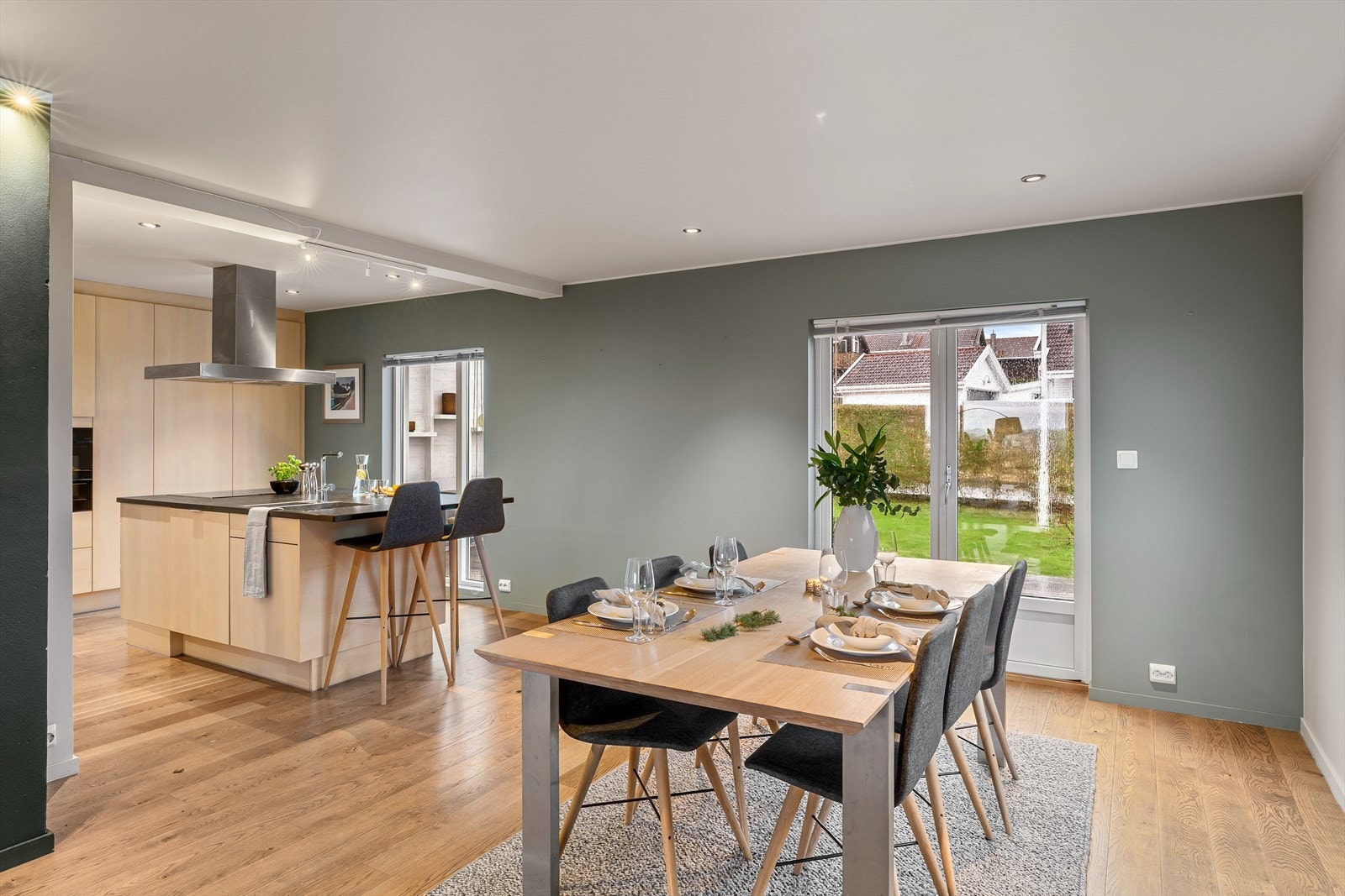 Moderne og tidløst kjøkkeninnredning fra HTH i hvitoljet eik, med benkeplate i stein og kjøkkenøy med frokostplass. Integrerte hvitevarer. Utgang fra kjøkknet til terrasse og hagestue, noe som gjør det enkelt å ta med middagen ut. Galleribilde