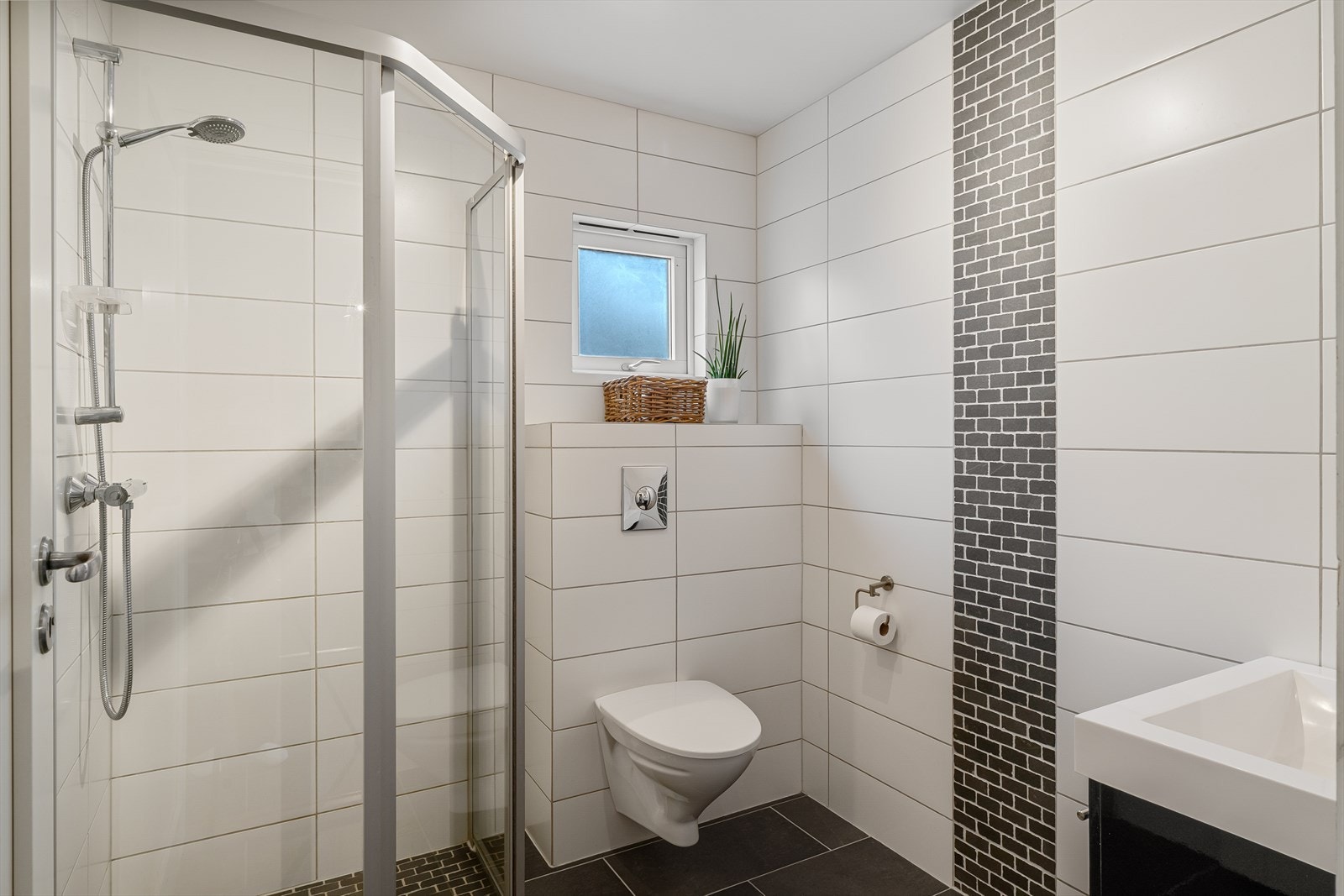 Pent helfliset baderom med gulvvarme, dusjnisje, vegghengt wc og vask i møbel Galleribilde