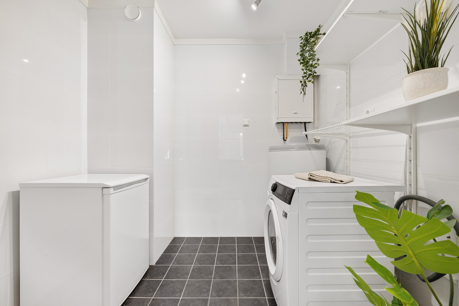 Separat og flislagt vaskerom fra 2018 med varmekabler i gulv. Her har du god plass til vaskemaskin, tørketrommel og ekstra fryser. Galleribilde