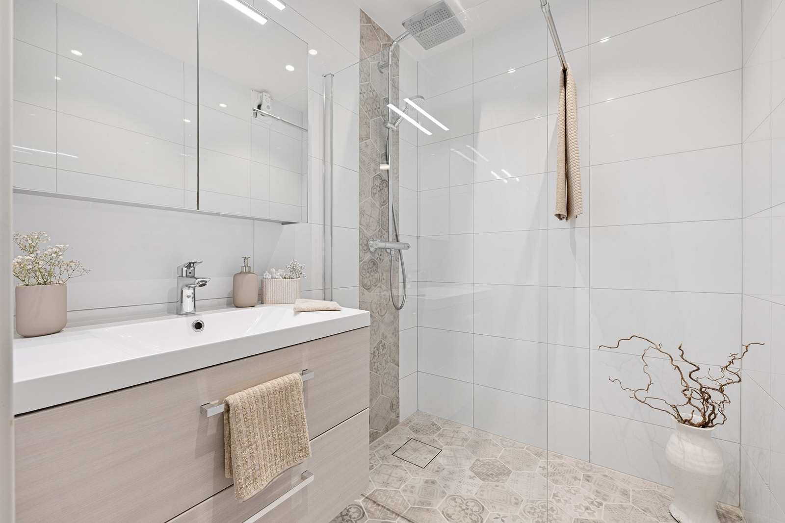 Delikat og flislagt bad fra 2018 med varmekabler i gulv. Moderne baderommsinnredning med skuffer og dusjsone med regnfall. Galleribilde