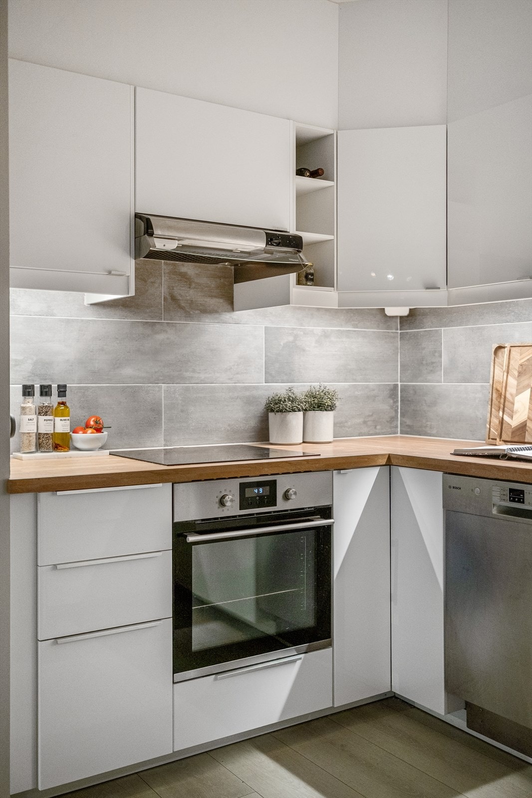 Integrerte hvitevarer og effektiv planløsning gjør dette til et funksjonelt og delikat rom for matlaging og hverdagsliv Galleribilde