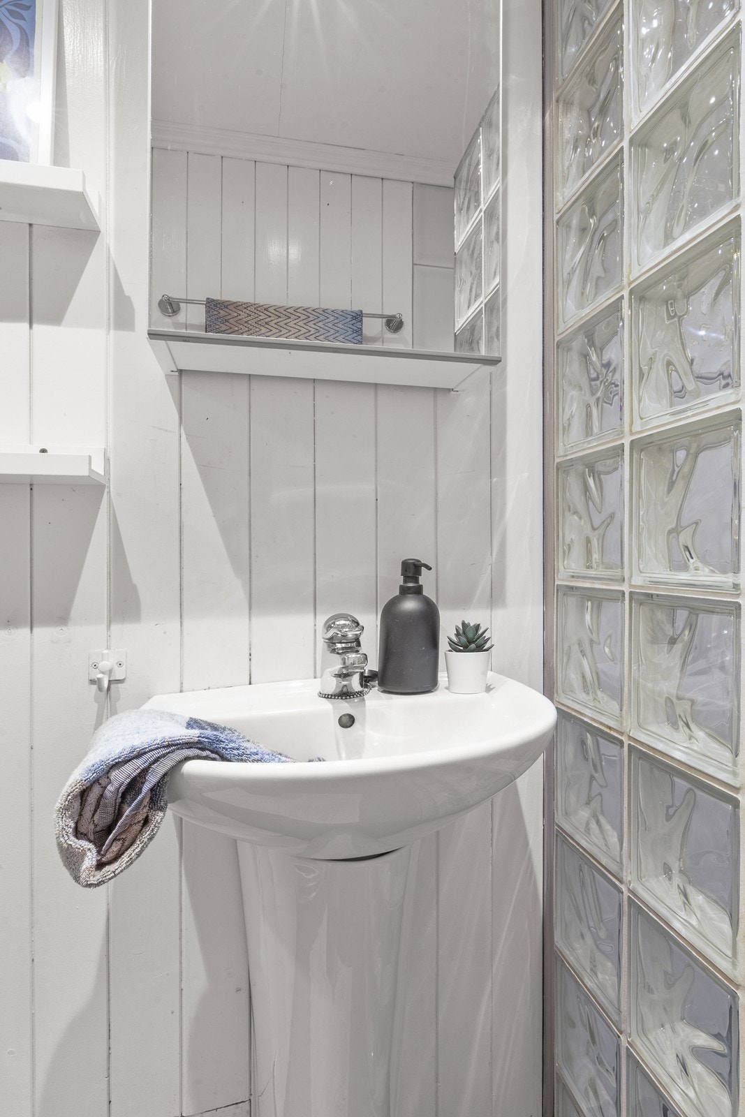 Bad med dusj nisje i glass byggestein, servant og tolaett. Galleribilde