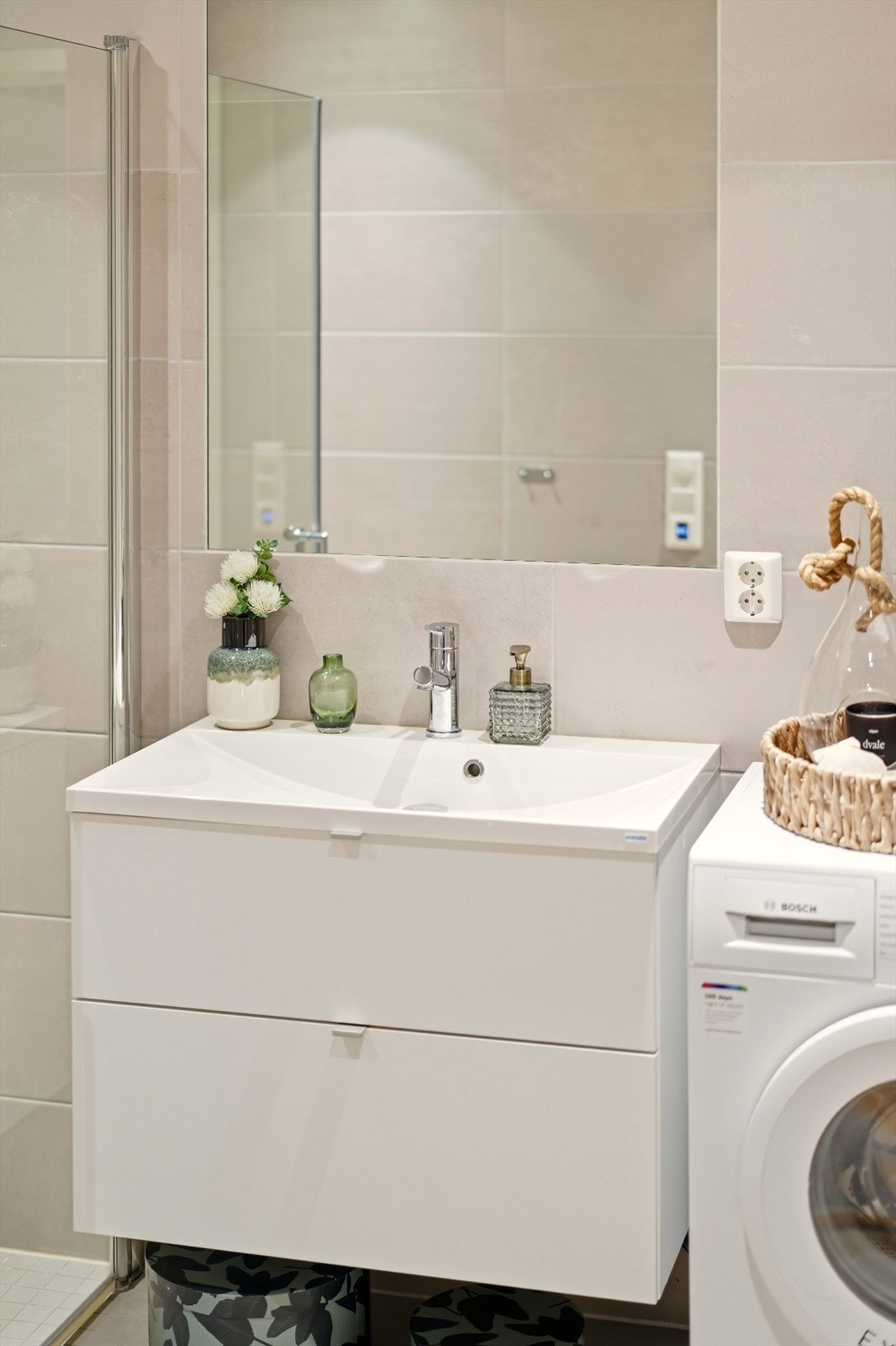 Badet har nedfelt servant med skuffer, speil og opplegg for vaskemaskin. Galleribilde