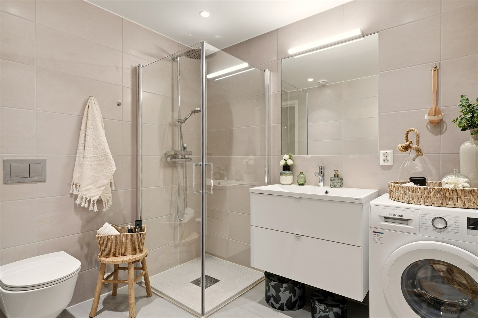 Leiligheten har et lyst og pent bad med flislagte overflater og downlights i himling. Galleribilde