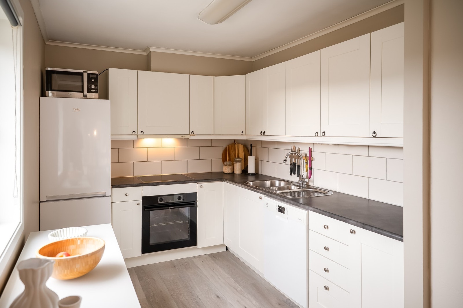 Pent kjøkken som har relativt godt med skap- og benkeplass Galleribilde