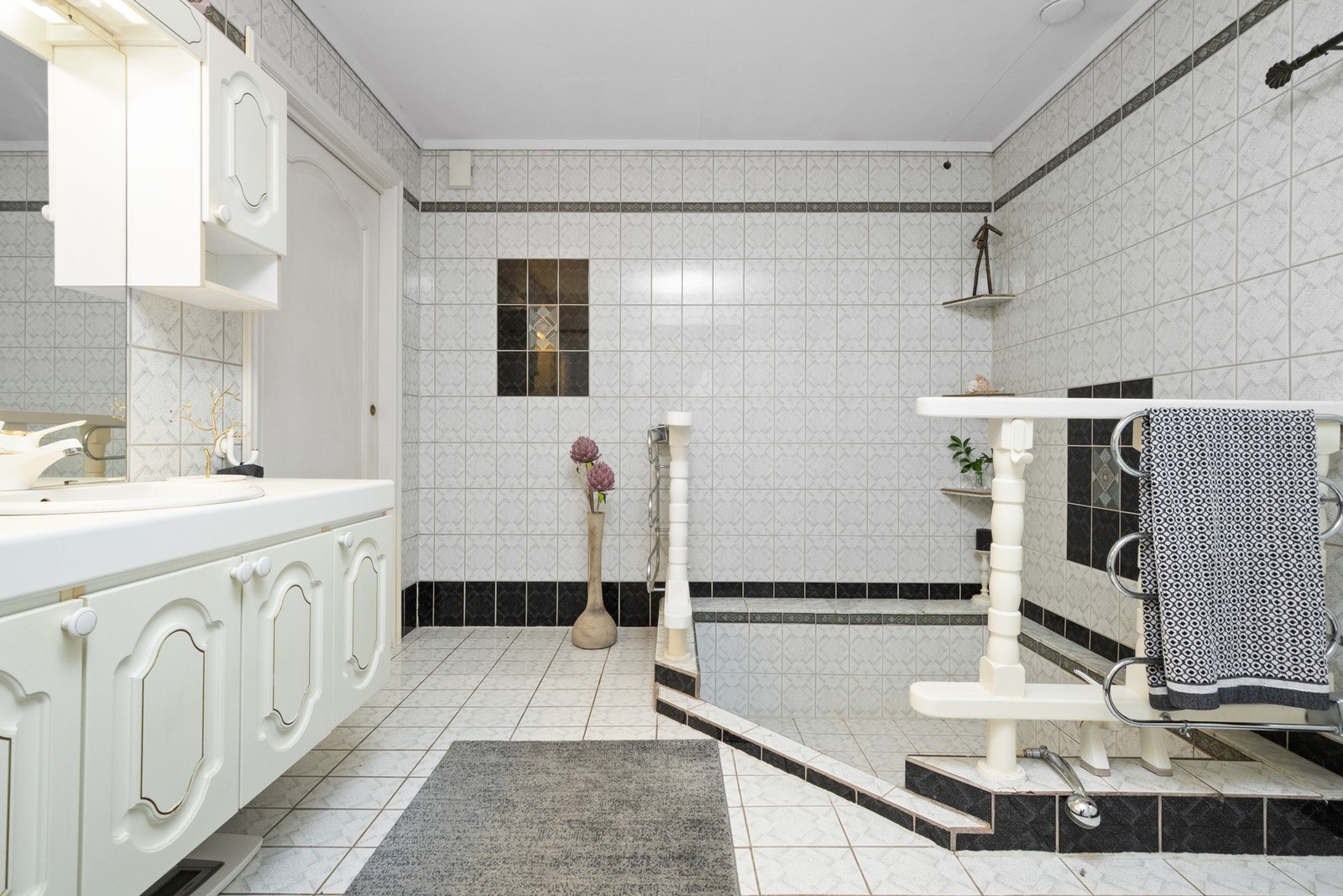 Innredning med 2 vasker, toalett og plassbygget/murt badekar som
er nedsenket. Galleribilde