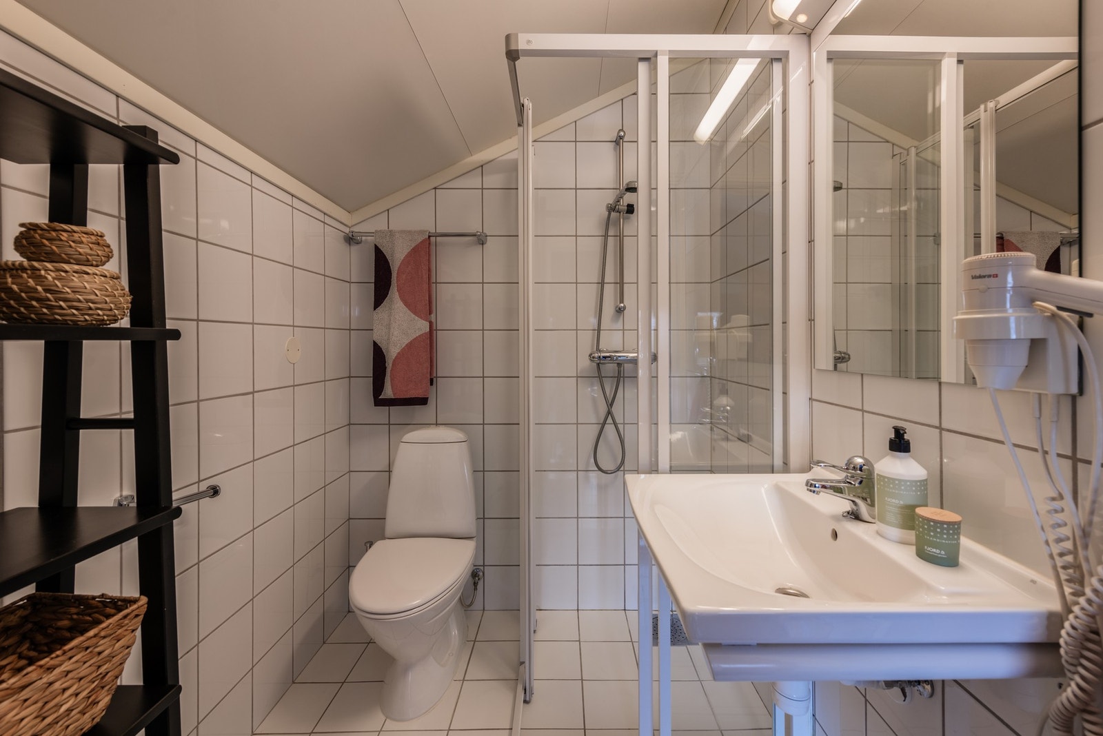 Badet har fliser på gulv og vegger og glatte plater i himling Galleribilde