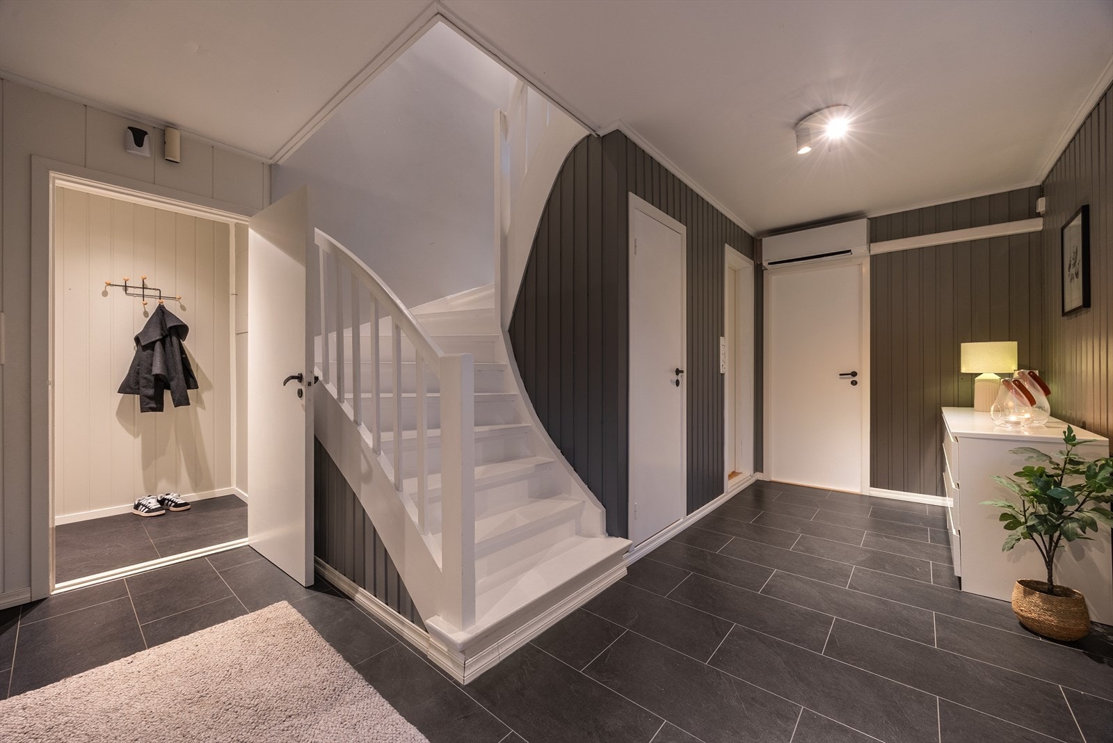 Stor hall som forgrener alle rommene i denne etasjen. Trapp opp til hovedetasjen. Galleribilde