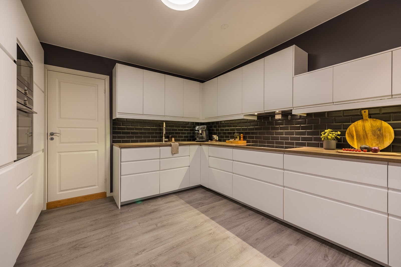 Fra kjøkkenet er det inngang til praktisk vaskerom og bod Galleribilde