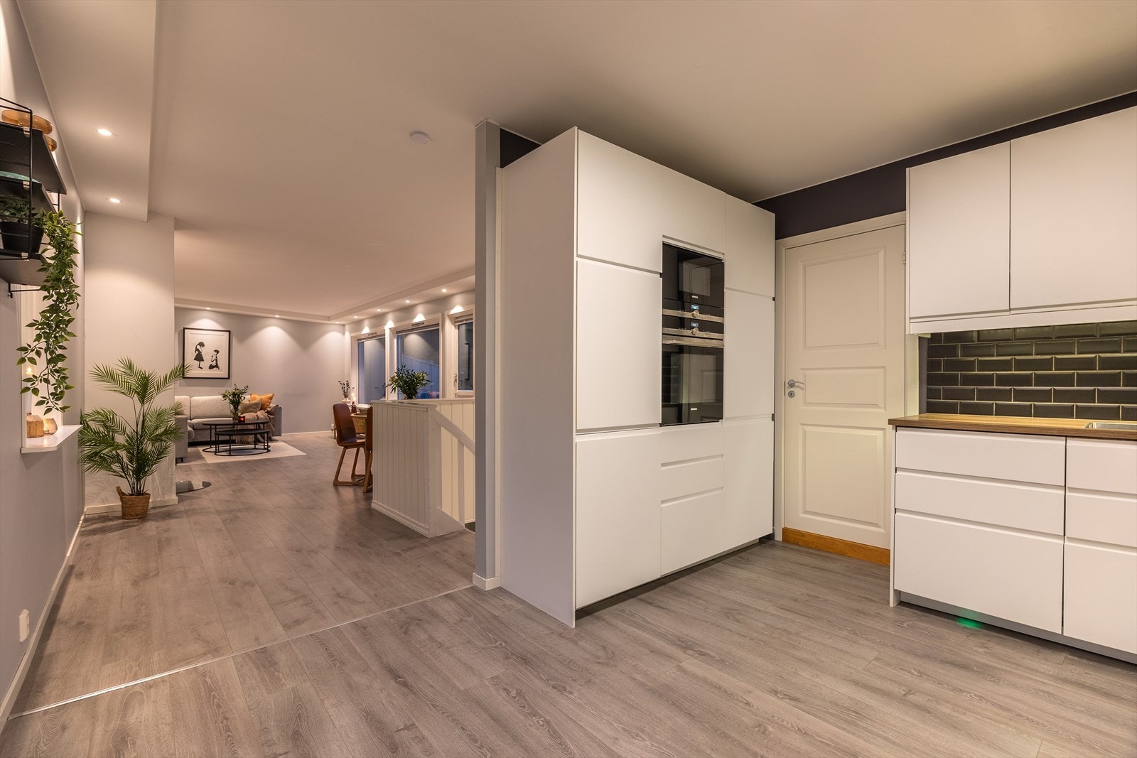 Kjøkkenet er moderne med hvite slette fronter og innredet med god skap- og benkeplass Galleribilde