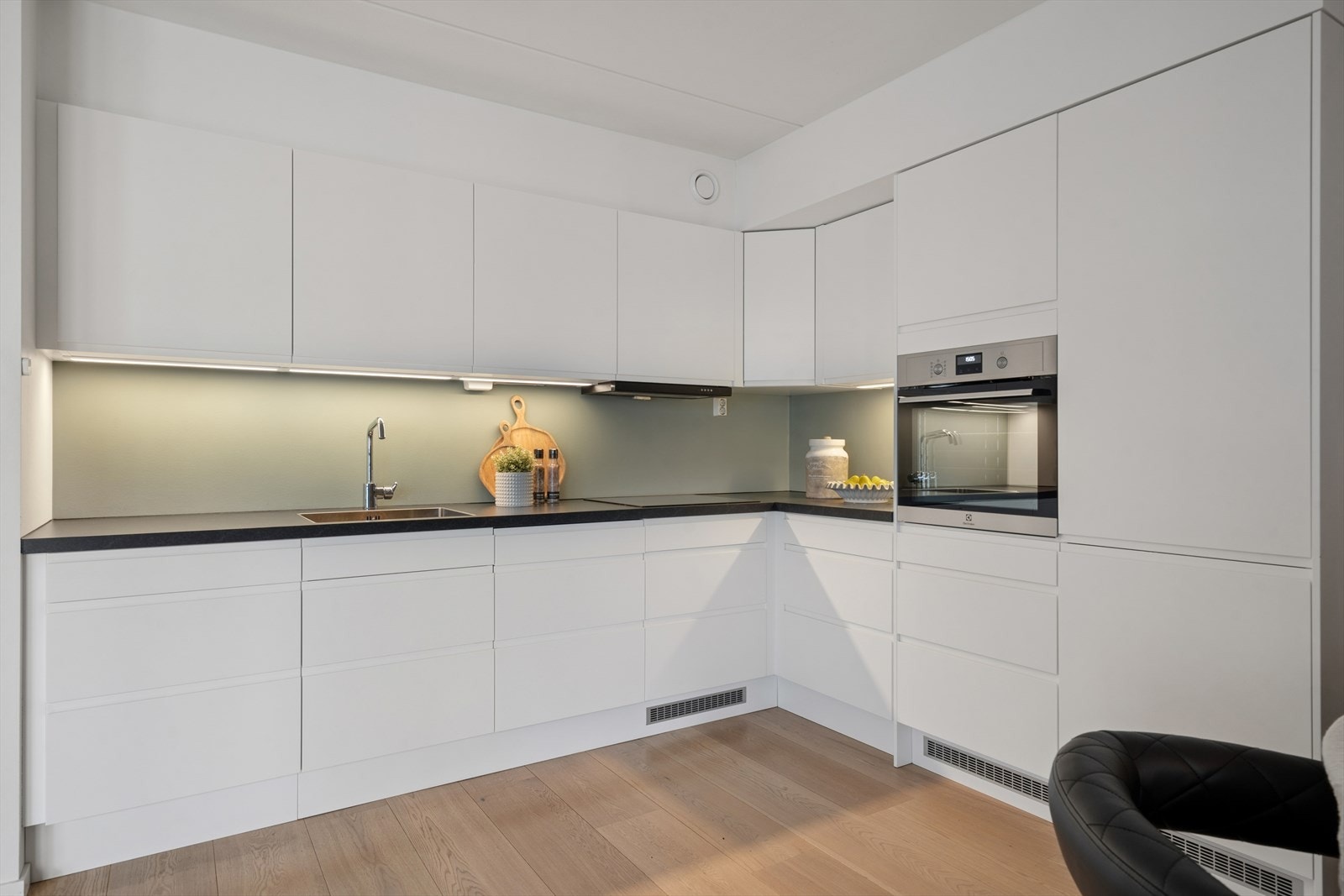 Kjøkkenet har en moderne innredning fra 2020 av typen Epoq, med lyse, glatte/folierte fronter og laminert benkeplate med rustfritt oppvaskbeslag. Galleribilde