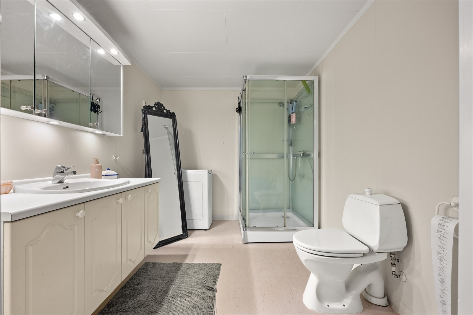 Romslig bad med malte baderomsplater på vegg og belegg gulv. Innredet med servantskap med god oppbevaring oppbevaring. Nytt speilskap med belysning, dusjkabinett montert 2010, toalett og opplegg for vaskemaskin. Rommet har elektriske varmekabler. Galleribilde