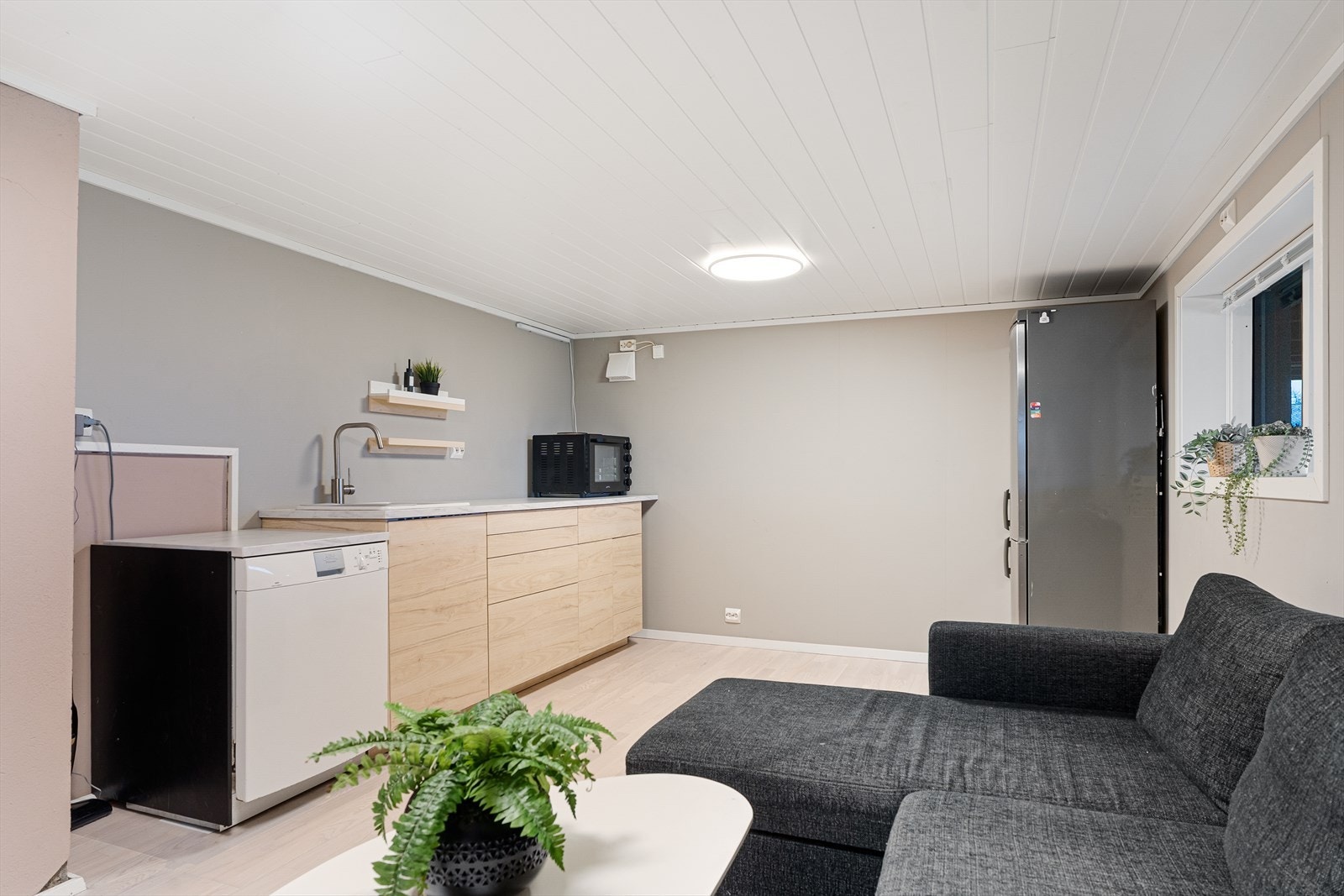 Kjøkkenet har innredning med slette fronter og laminat benkeplate Galleribilde