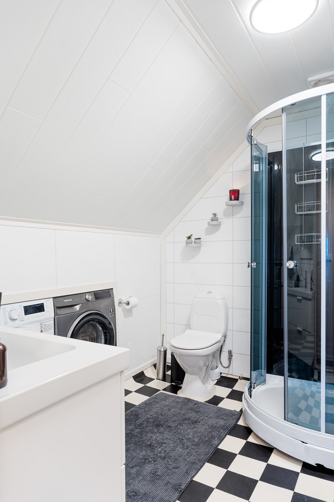 Lyst bad/vaskerom med vinylbelegg på gulvet, baderomsplater på veggene og MDF-panel i himlingen Galleribilde