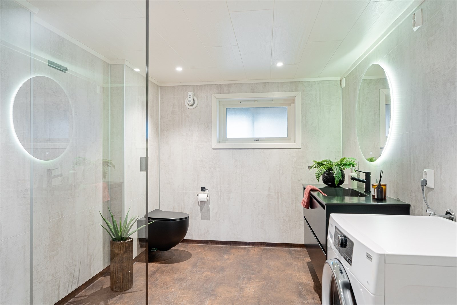 Lyst og flott bad som ble renovert i 2021 - badet har baderomsplater på veggene og vinylbelegg på gulvet med elektriske varmekabler Galleribilde