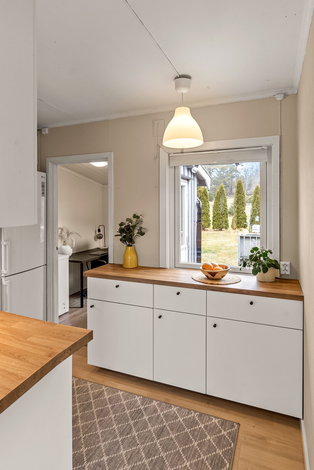 Fra kjøkkenet er det tilgang til et praktisk innredet rom med utgang til terrassen. Galleribilde