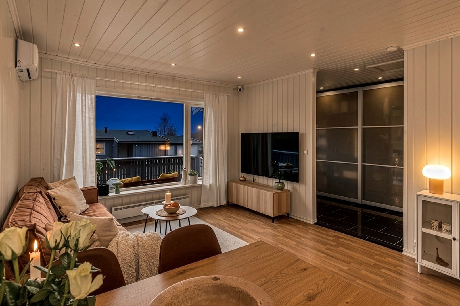 Stuen sett mot gangen, som har en romslig skyvedørsgarderobe for oppbevaring. Galleribilde