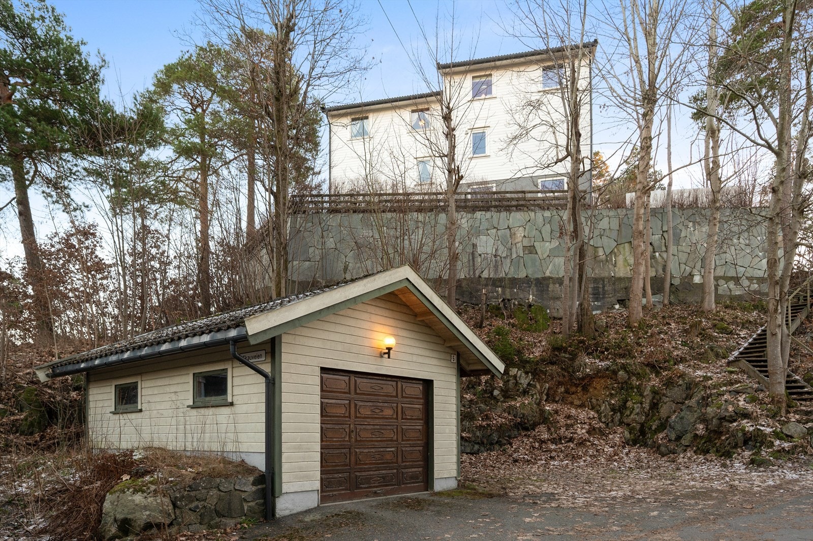 Frittliggende enkelgarasje tilhørende boligen. Rett til å disponerer trapp opp til eiendommen. Galleribilde