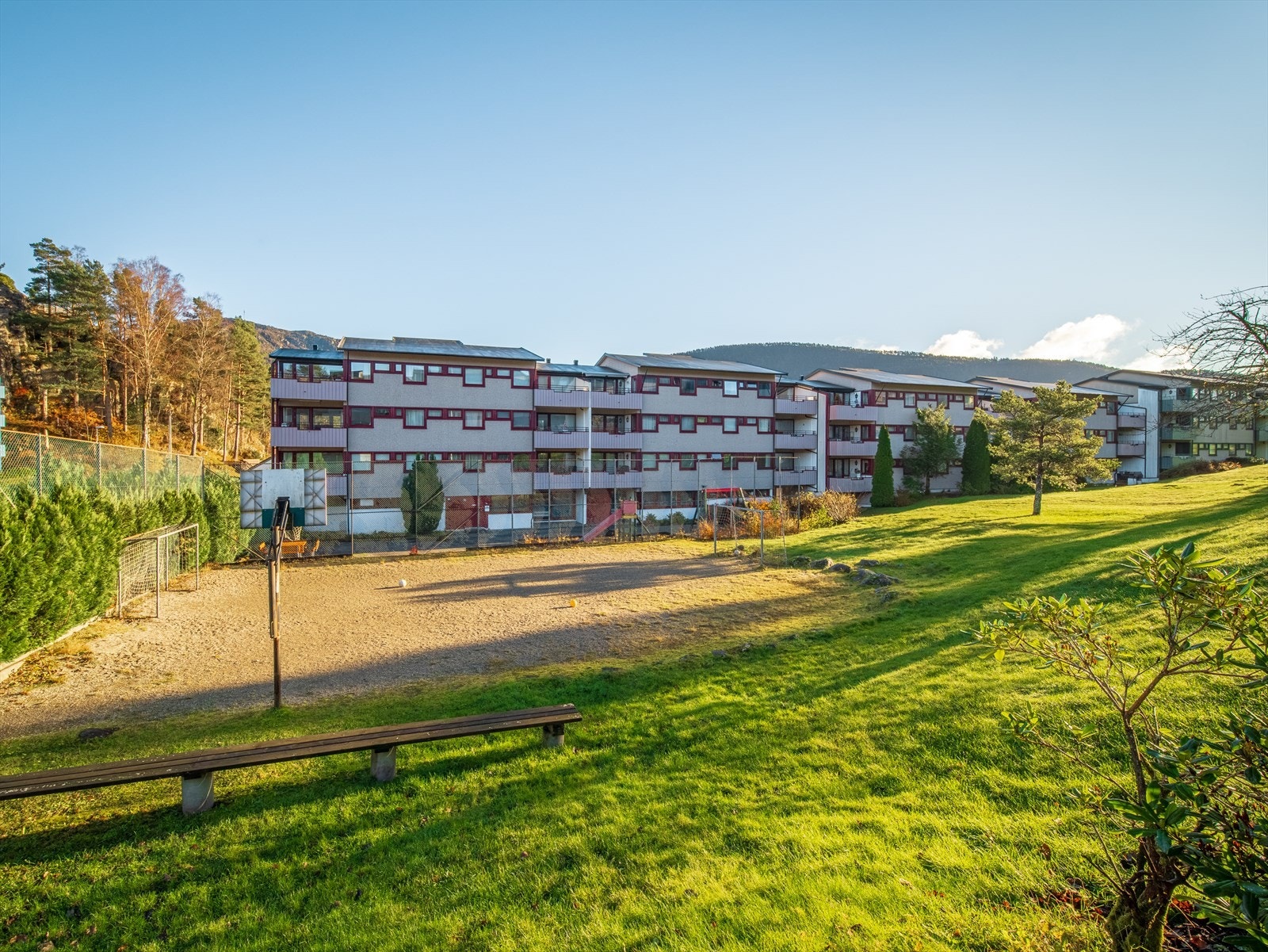 Store fellesarealer i borettslaget med fine grøntareal, lekeplasser, benker og parkeringsareal. Galleribilde