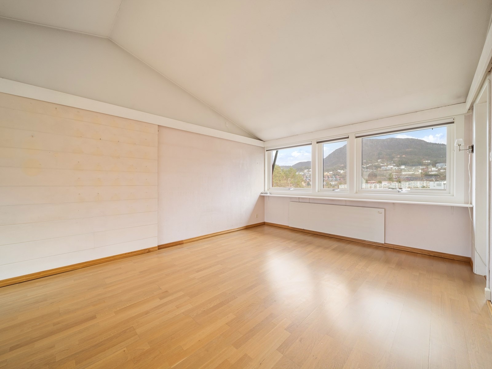 Lys og luftig stue med høy himling og vindu på begge sider som gir godt med naturlig lys. Galleribilde