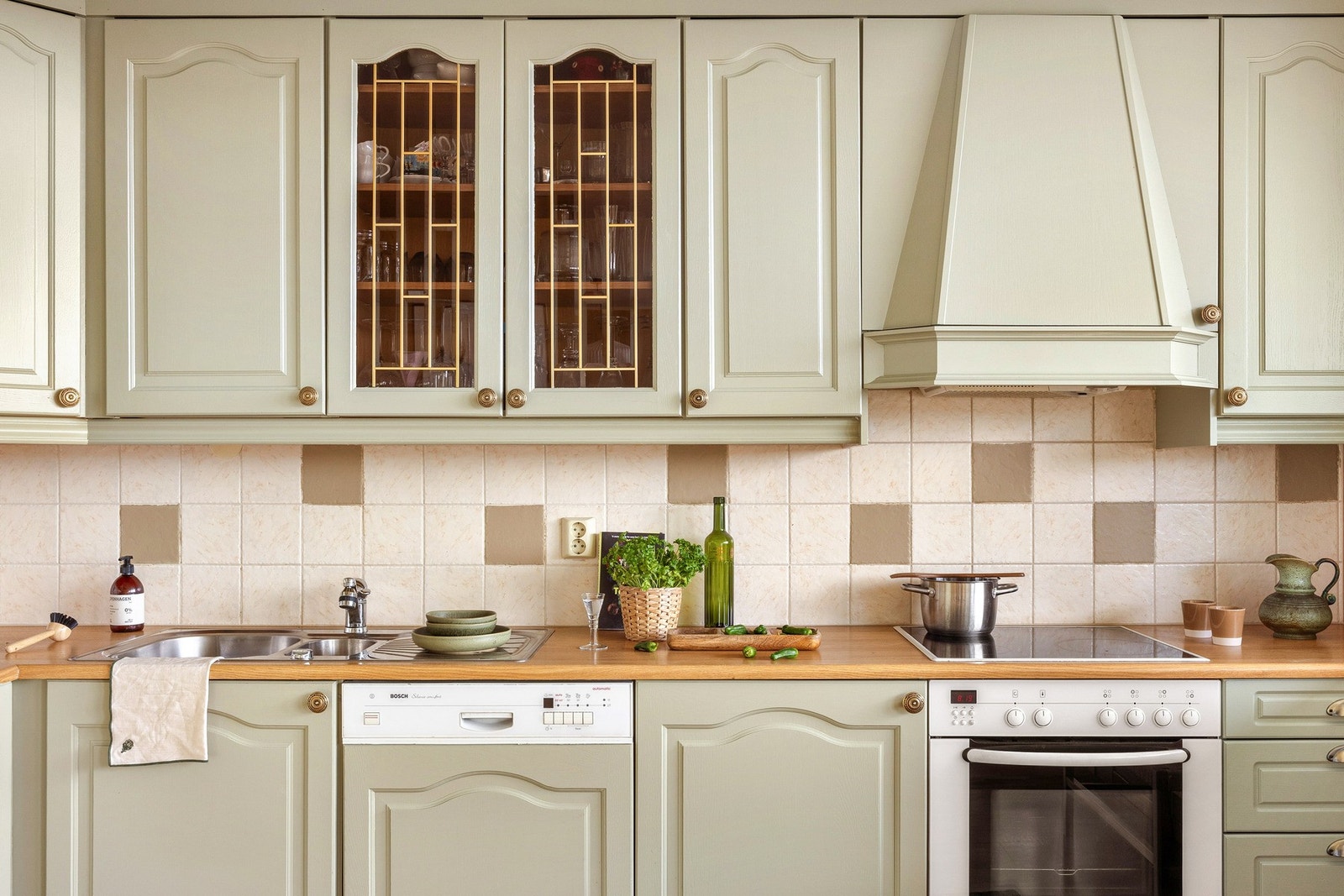 Kjøkkeninnredningen har profilerte fronter, glasskap og benkeplate av laminat med nedfelt vask av stål. Galleribilde