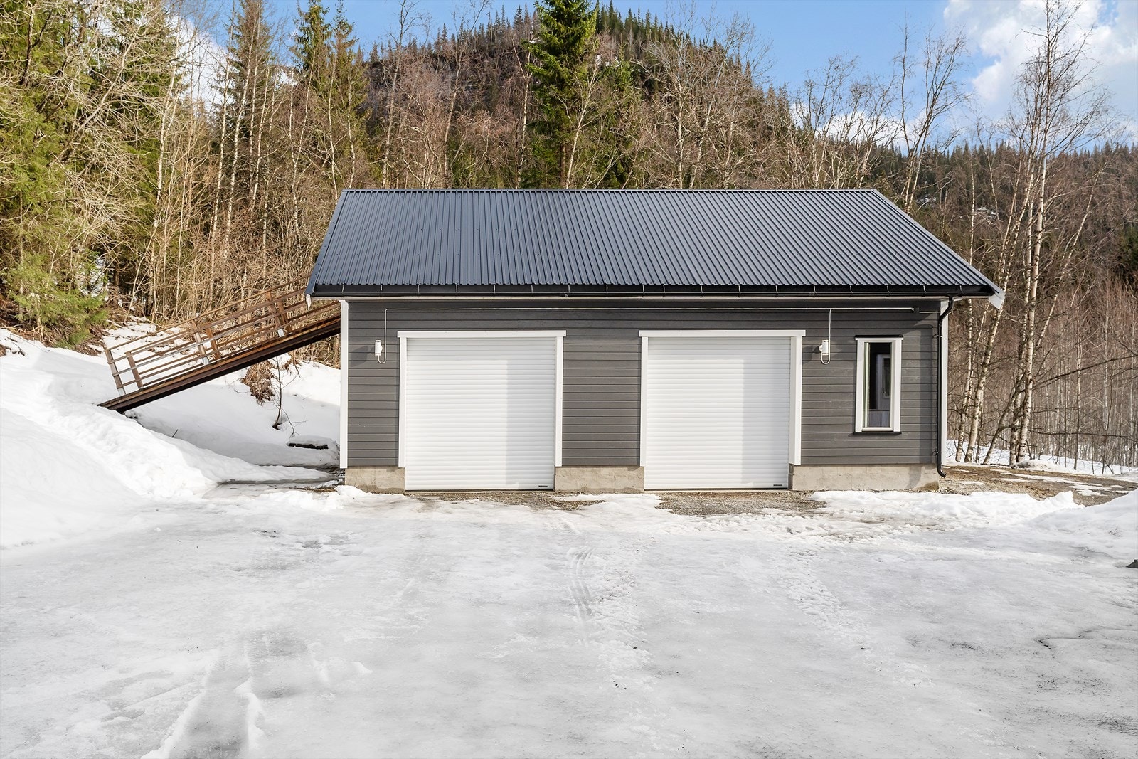 Svært romslig garasje som er isolert, plateslått og som har innlagt strøm. Portåpner på begge porter. To yttervegger er umalte. Galleribilde