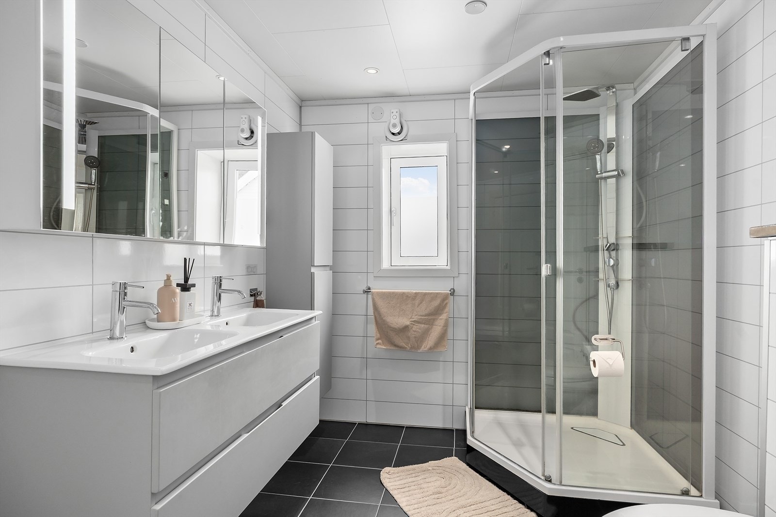 Lekkert bad i 2.etasje med dusjkabinett, toalett, overskap med hyller, langskap og innredning med to nedfelte vasker. Galleribilde