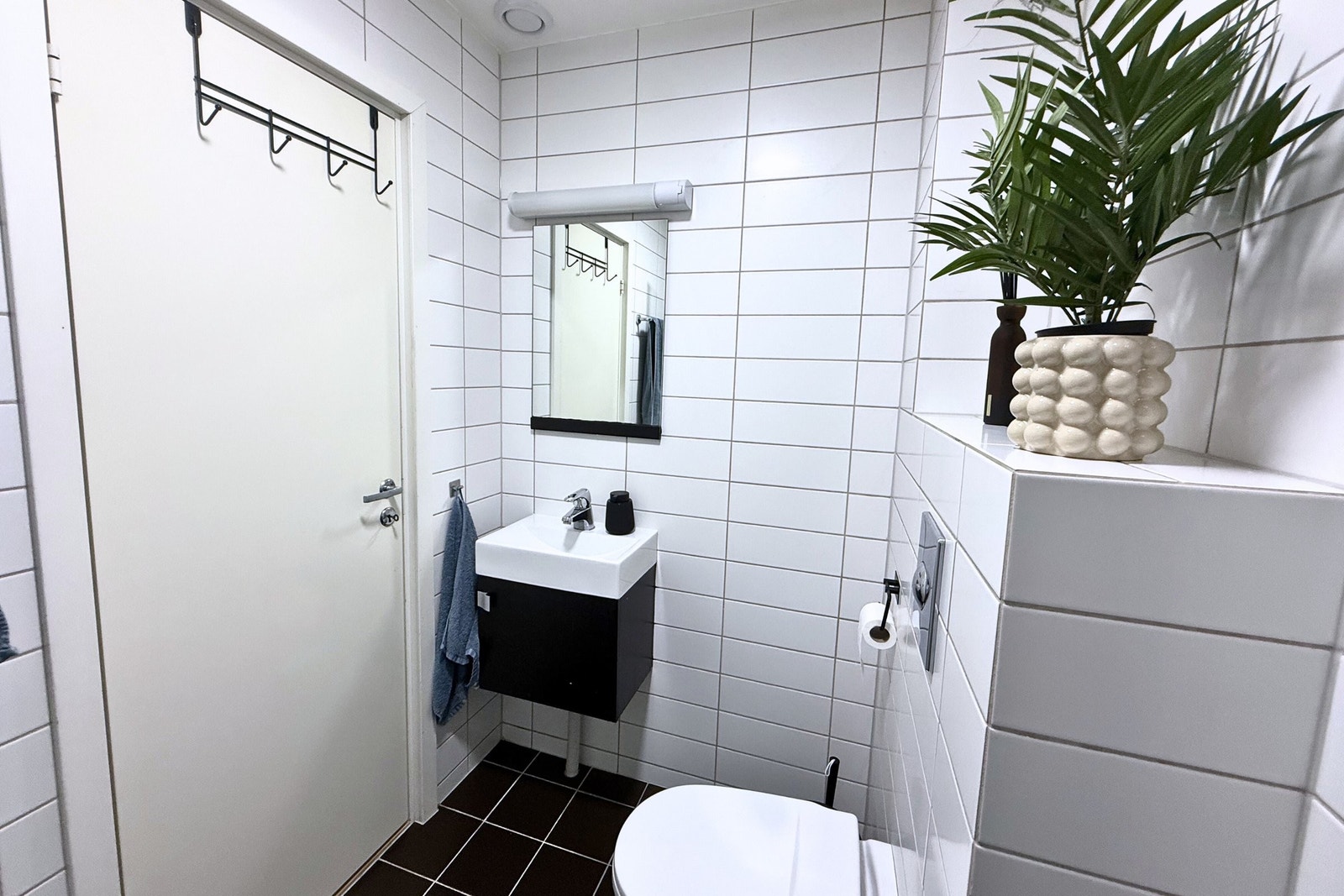 Kompakt og funksjonelt bad med servant, speil og gode oppbevaringsmuligheter. Galleribilde