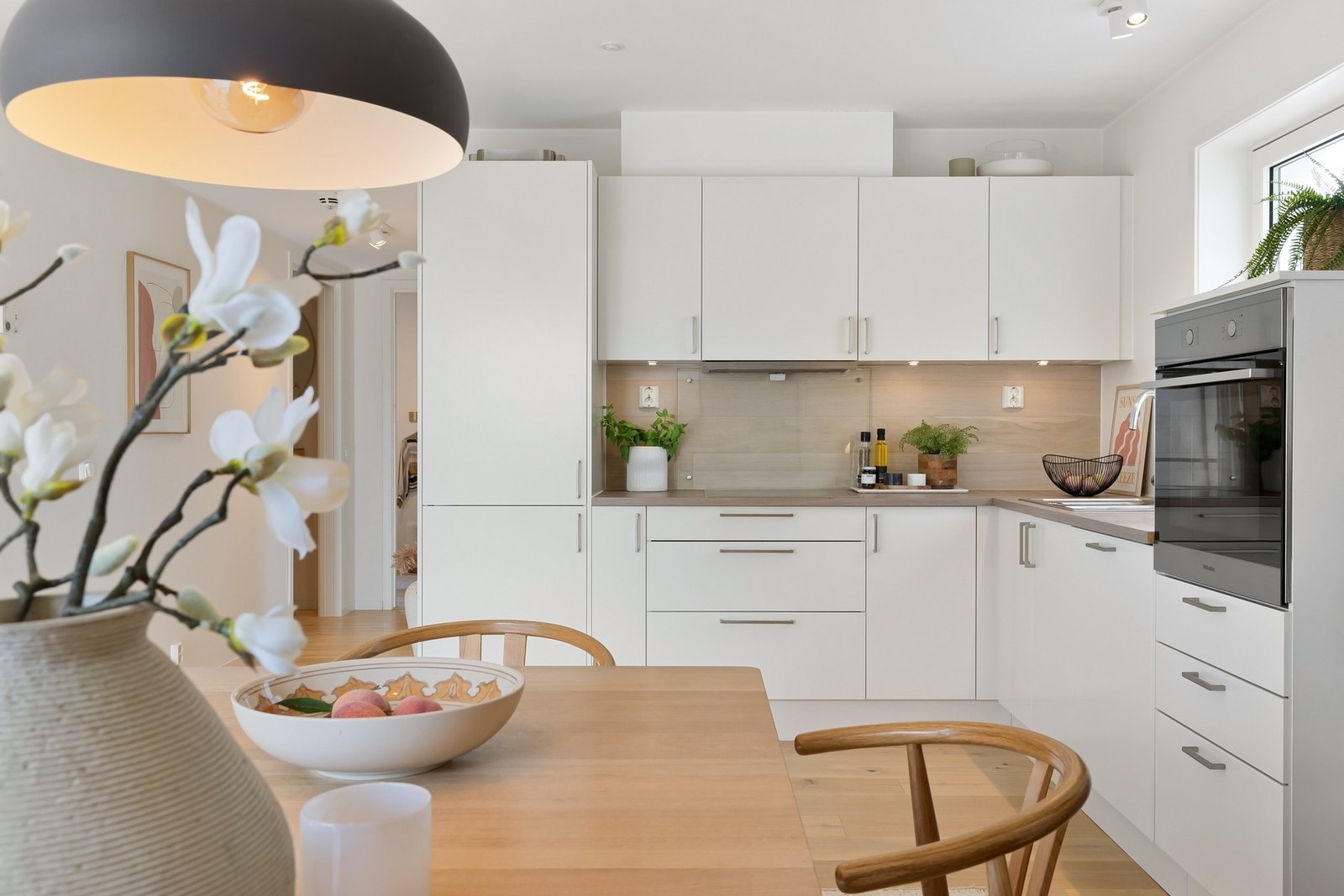 Benkeplaten i laminat gir en robust og lettstelt arbeidsflate, og det er nedfelt koketopp med ny ventilator fra 2026, integrert stekeovn samt oppvaskmaskin. Galleribilde