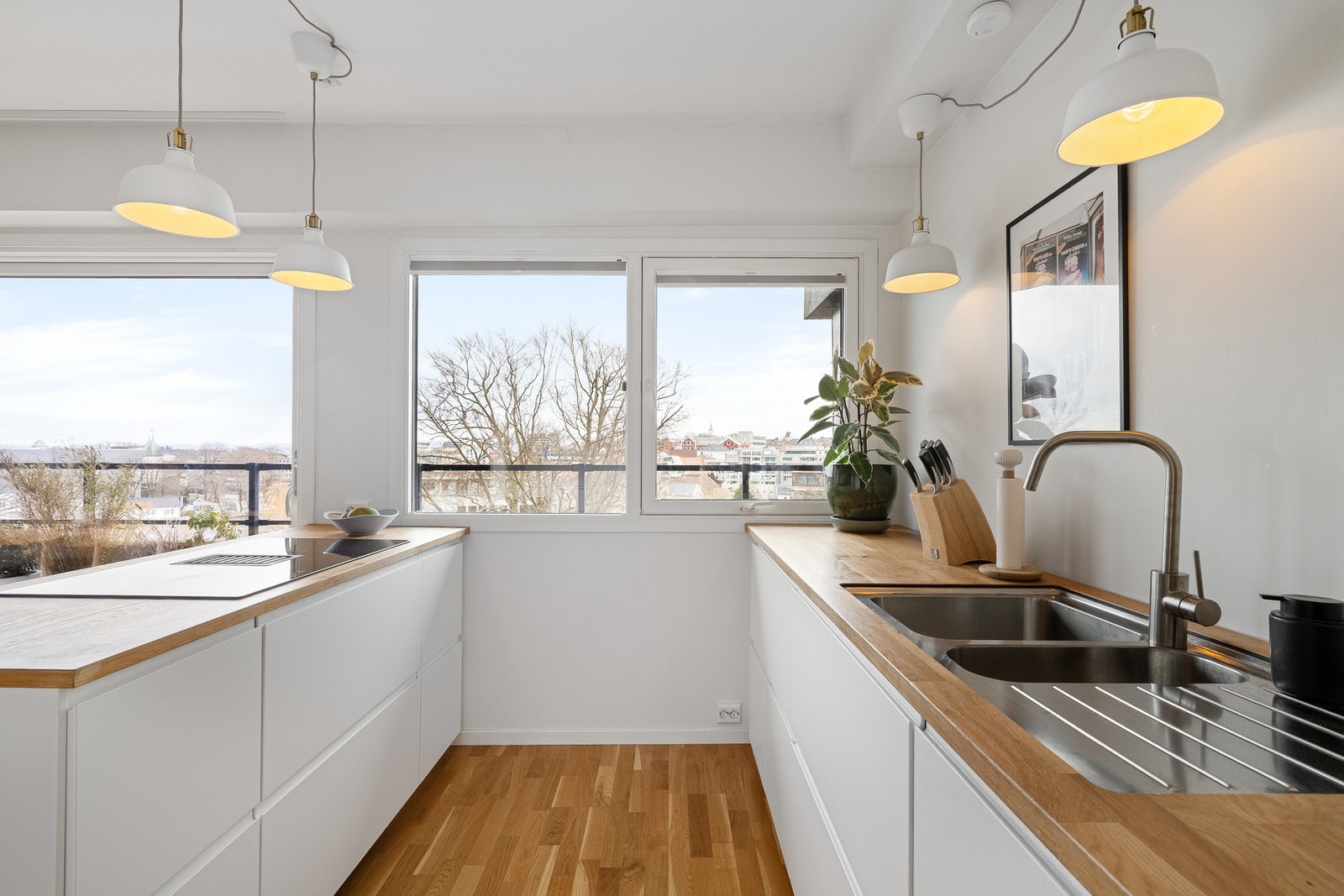 Induksjonstopp med avtrekk på kjøkkenøy. Her kan du tilberede middag, samtidig som du holder gjestene med selskap. Galleribilde