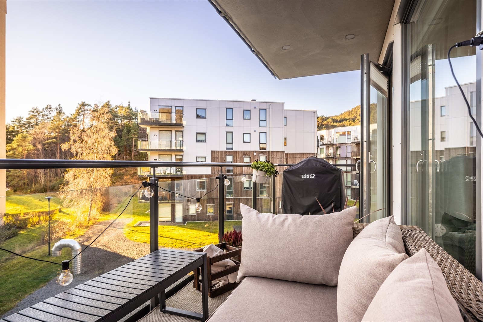 Balkongen har praktisk overbygg, strømuttak og glassrekkverk. Galleribilde