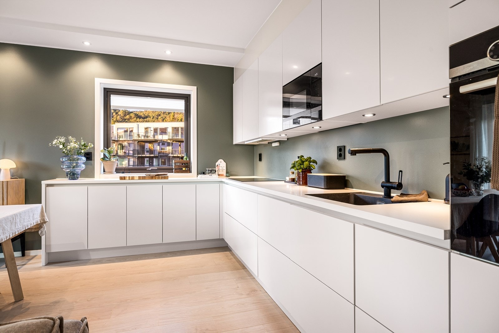 Flott hvitt kjøkken komplett med alle hvitevarer som steikeovn, stekeplate, oppvaskmaskin og micro. Galleribilde