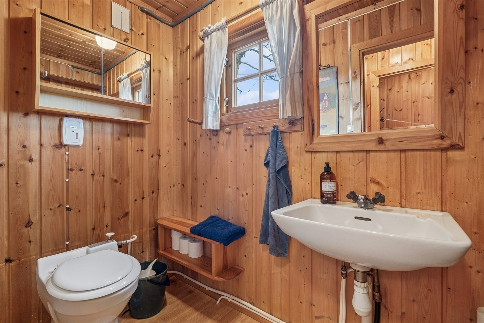 Toalettrommet er utstyrt med gulvmontert toalett, servant og speil. Galleribilde