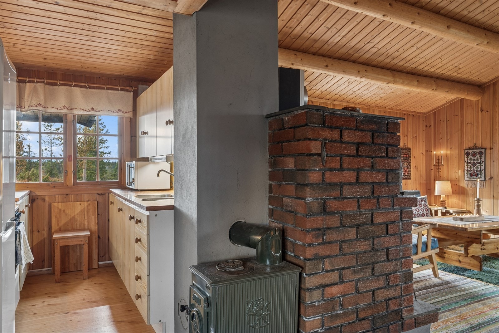 Kjøkkenet er plassert i en egen sone, sentralt i hytta og med en vedovn for ekstra varme. Galleribilde