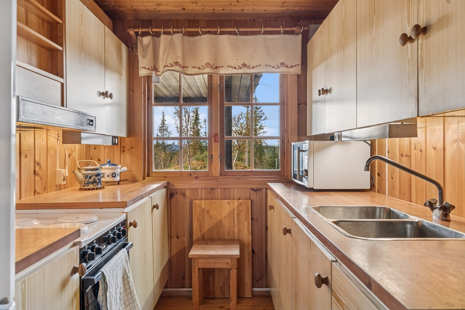 Kjøkkeninnredningen har laminert benkeplate og glatte fronter, med plass til frittstående hvitevarer. Galleribilde