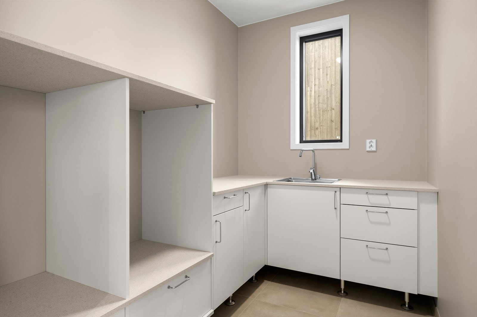 Vaskerom med praktisk innredning og nisjer i høyden for både vaskemaskin og tørketrommel Galleribilde