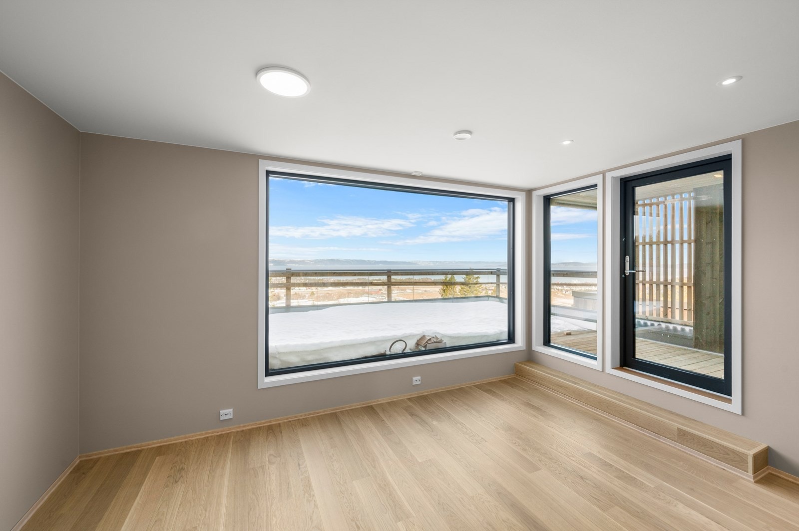 Stue på plan.2 med store vindusflater og downlights i himling Galleribilde