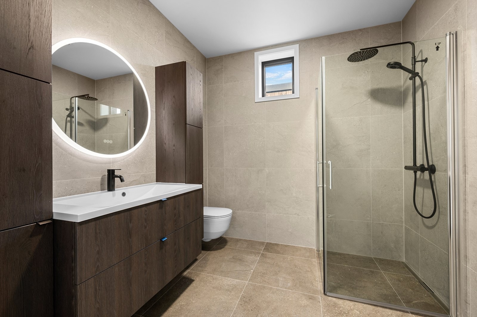 Baderom med 60x60 flis på veger og gulv samt gulvvarme. Regndusj for ekstra luksus i hverdagen og godt med med oppbevaring med soft-close Galleribilde