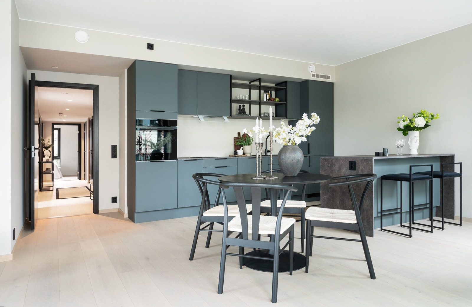 Kjøkkenet er plassert mellom stue og spisestueavdeling og skaper et naturlig skille mellom sonene Galleribilde