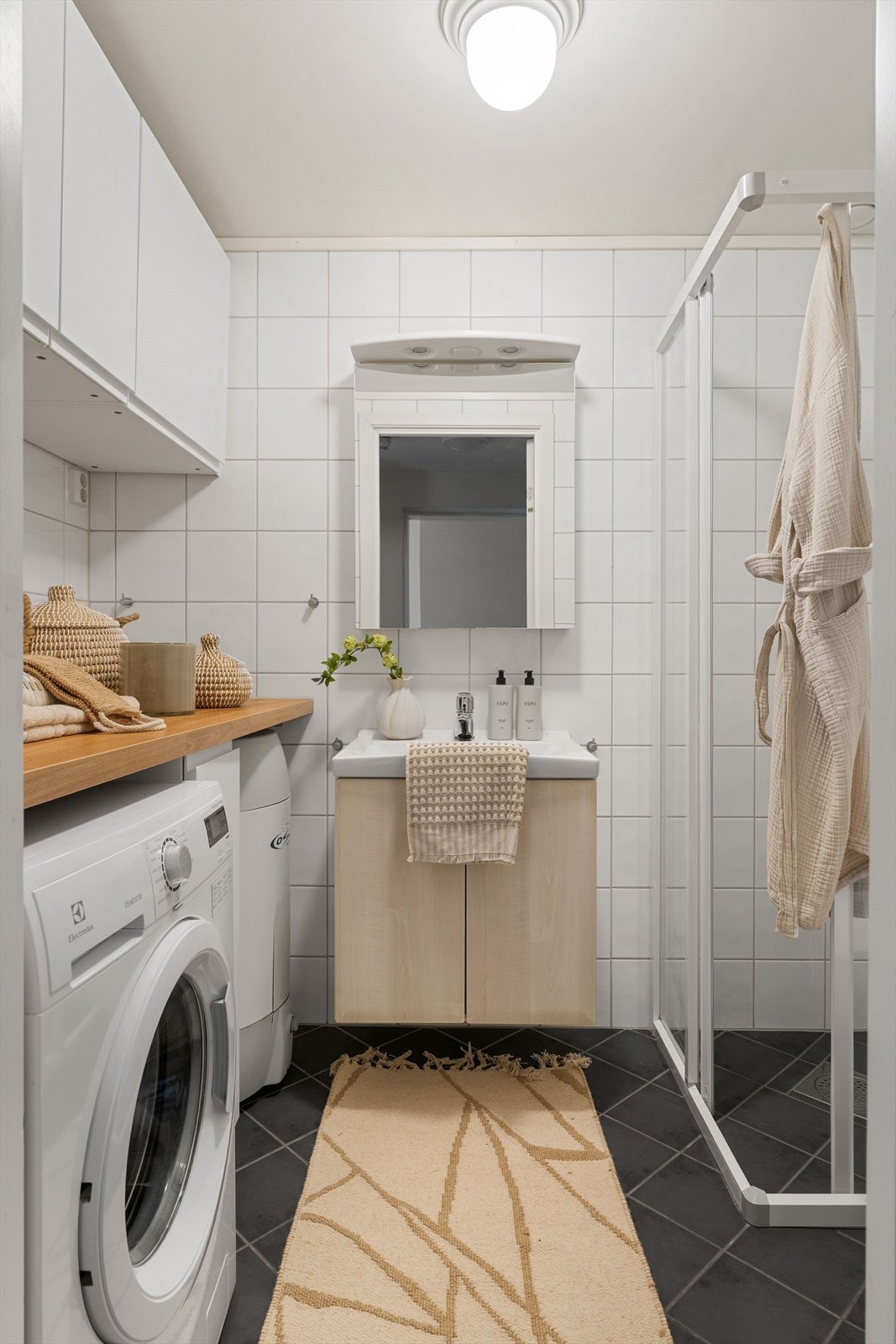 Badet har en praktisk innredning med egen benk over vaskemaskin som gir godt med arbeidsplass og oppbevaring. Galleribilde
