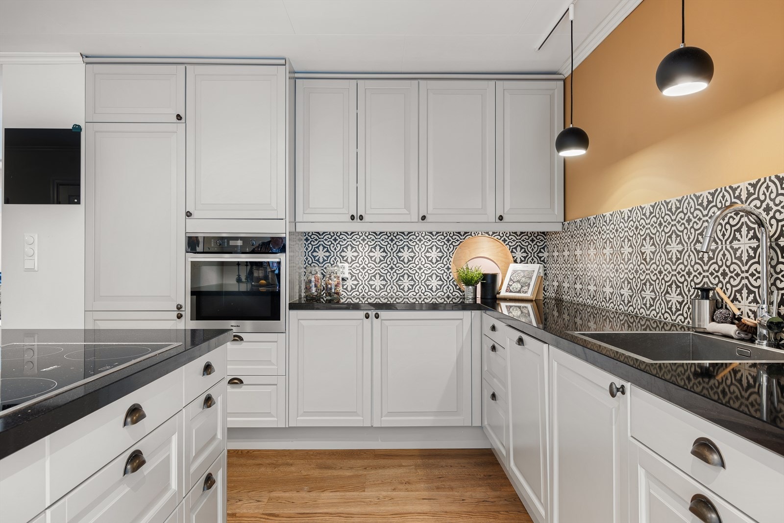 Pent kjøkken med fliser over benk og alle hvitevarer integrert Galleribilde