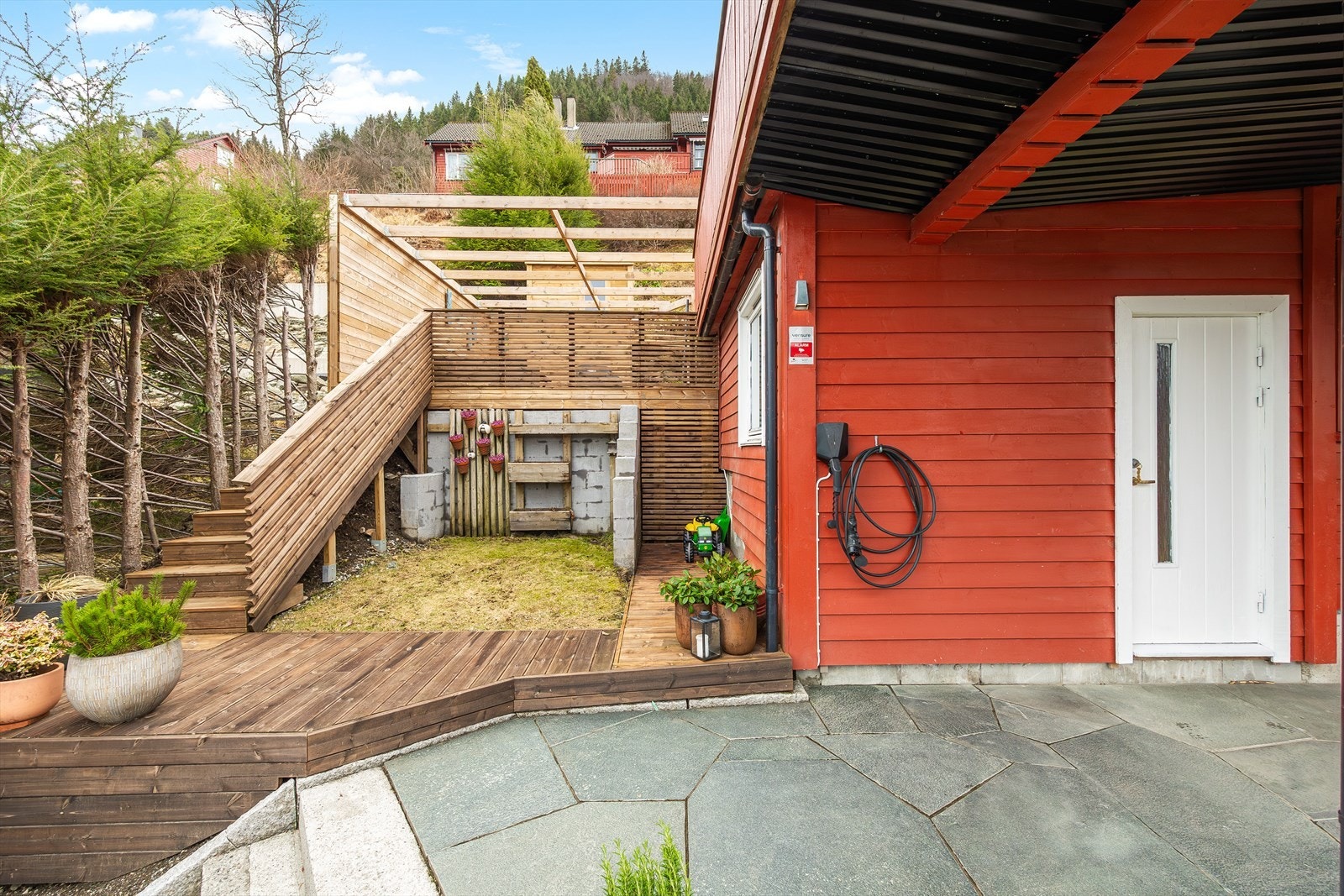 Fine opparbeidede utearealer på tomten - Trapp opp til terrasse v/besøk sommerstid - El-bil lader - Utvendig vannkran - Ny flott støttemur mot vei av naturstein i 2023 - Steintrapp og skiferbelagt inngangsparti Galleribilde