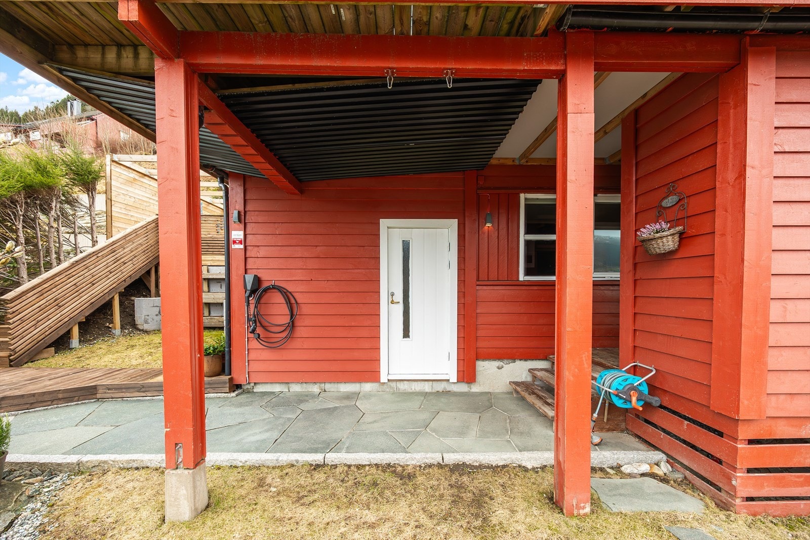 Overbygget inngangsparti - Hvit dør til utvendig bod / treningsrom - Skiferbelagt adkomstvei Galleribilde