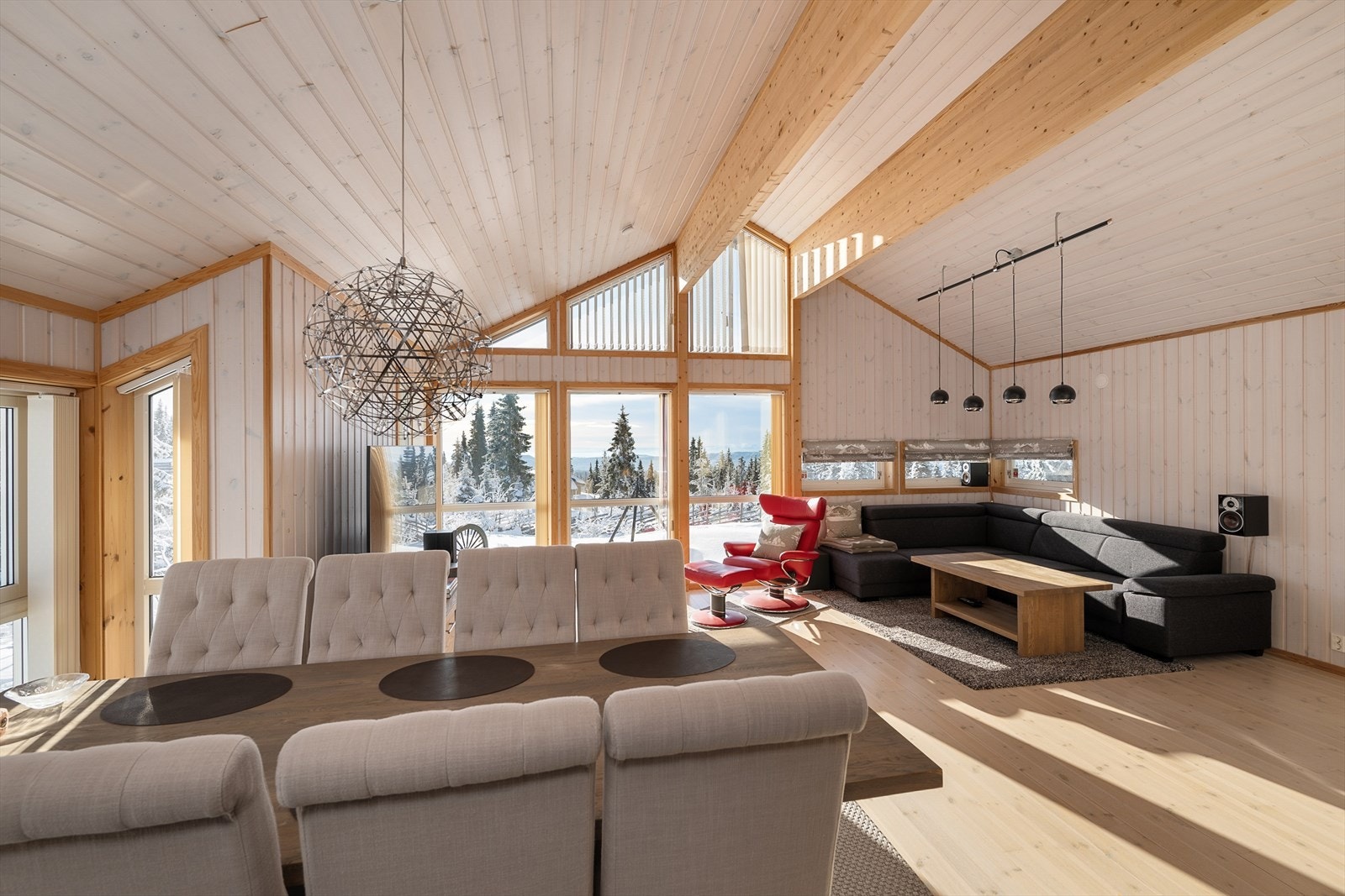 Det åpne allrommet forener stue, spisestue og kjøkken, med synlig limtrebæring som gir en luftig takhøyde. Galleribilde