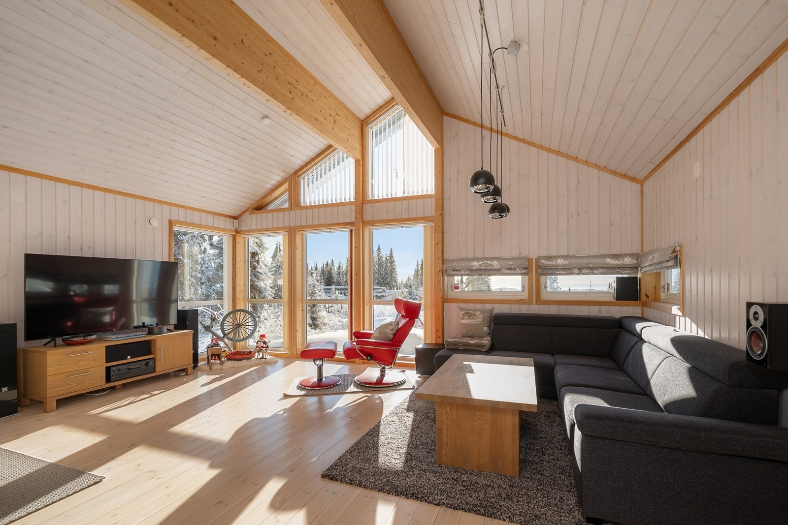 Stuen har tradisjonelt furugulv og store vinduer som rammer inn vinterlandskapet. Galleribilde